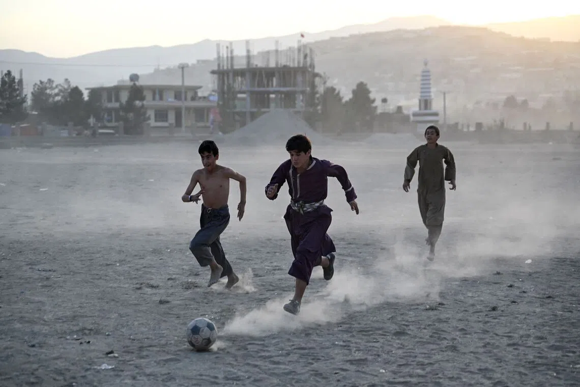 TOPSHOT - Afghan boys play football on a field in Fayzabad district of Afghanistan's Badakhshan province on September 30, 2026. (Photo by Omer ABRAR / AFP)