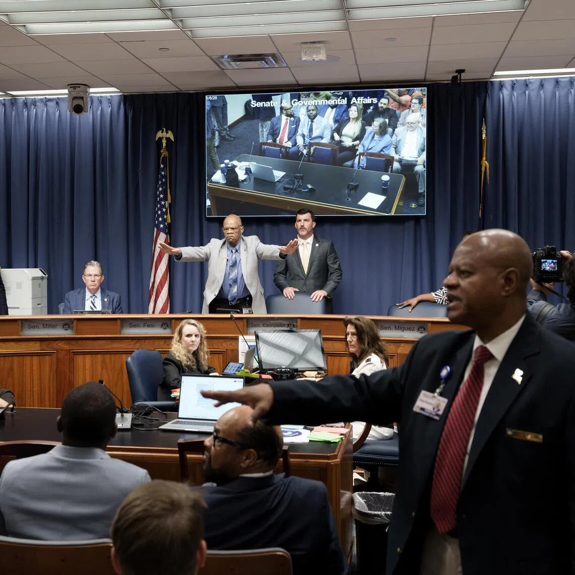 A member of the staff tries to calm the crowd during a public hearing on redistricting in Baton Rouge, Louisiana, on May 8, as Louisiana Republicans pursue a new congressional voting map ahead of the November midterm elections.