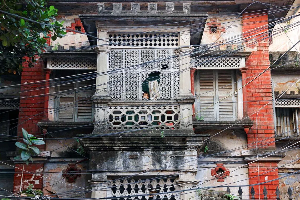 A child looking through a broken wall of an old building in Dhaka, Bangladesh, Oct 14, 2024. 
