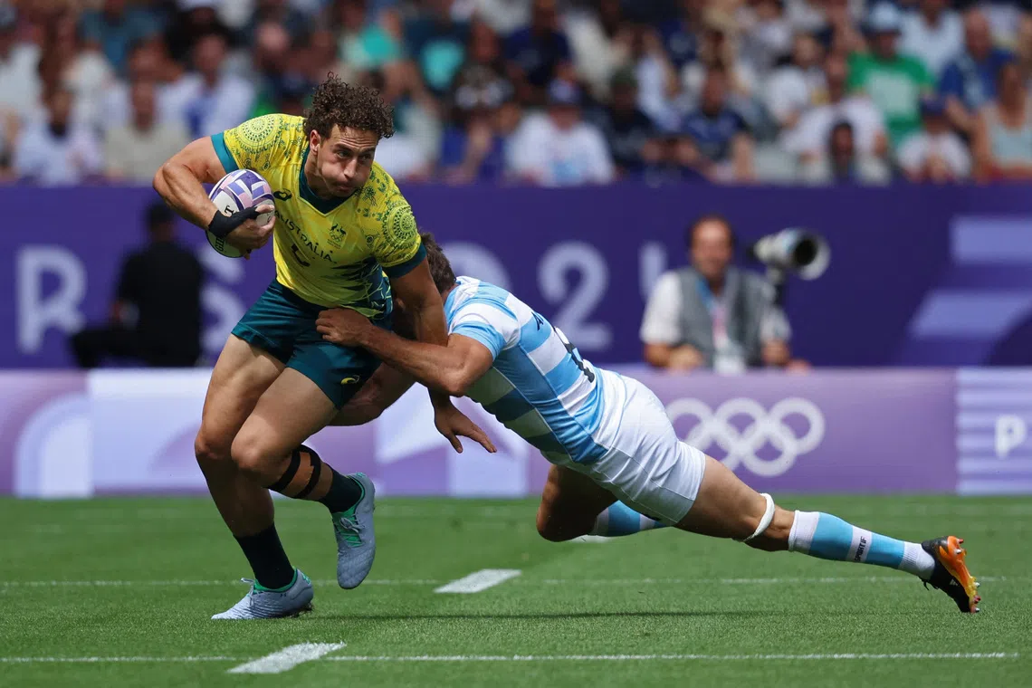 Paris 2024 Olympics - Rugby Sevens - Men's Pool B - Argentina vs Australia - Stade de France, Saint-Denis, France - July 25, 2024. Mark Nawaqanitawase of Australia in action with Santiago Alvarez of Argentina. REUTERS/Phil Noble
