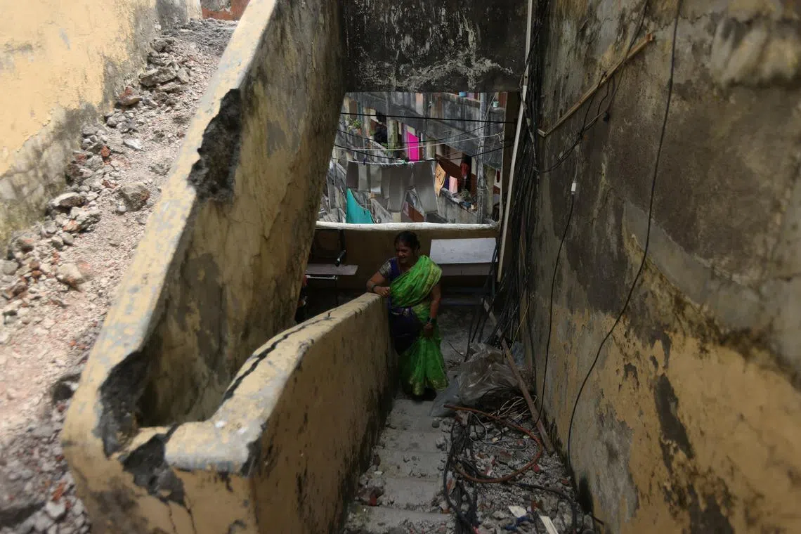 A resident standing on a damaged staircase at the Worli dairy quarters building on Oct 5, 2022. The building faces the sea, making the structure very vulnerable during monsoon season and the walls and doors of many units waterlogged and mouldy. 