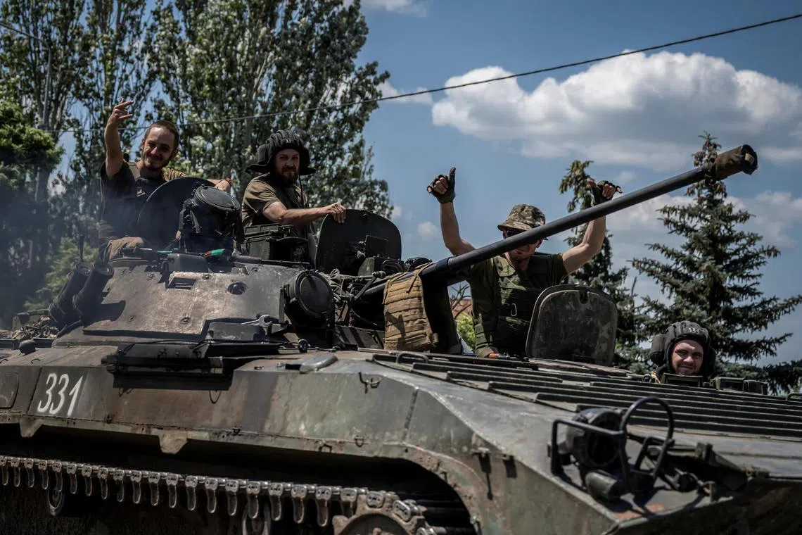 Ukrainian servicemen ride a BMP-1 infantry fighting vehicle, near the front-line city of Bakhmut, in Ukraine's Donetsk region.