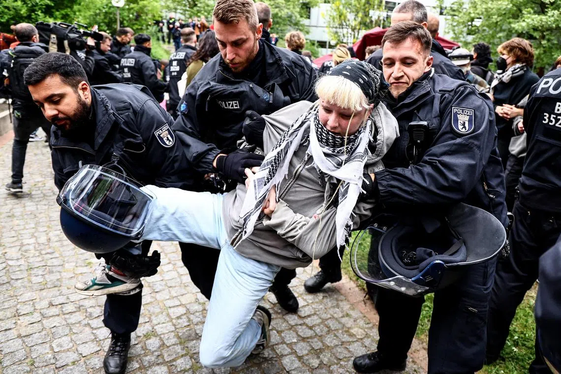 Police officers detain a protester, as they try to dismantle a pro-Palestinian camp at the Free University of Berlin, in Germany.