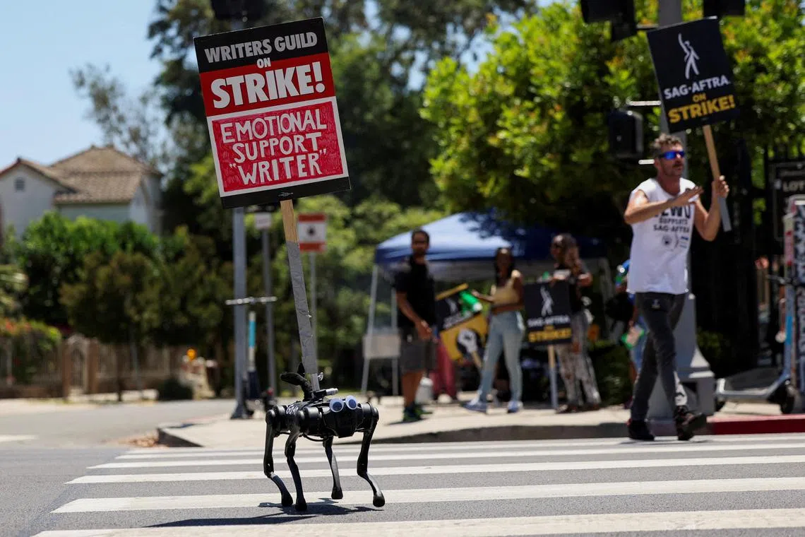 FILE PHOTO: A robot dog named Gato moves with a sign on it as SAG-AFTRA actors and Writers Guild of America (WGA) writers walk the picket line during their ongoing strike outside Paramount Studios in Los Angeles, California, U.S., August 2, 2023. REUTERS/Mario Anzuoni/File Photo