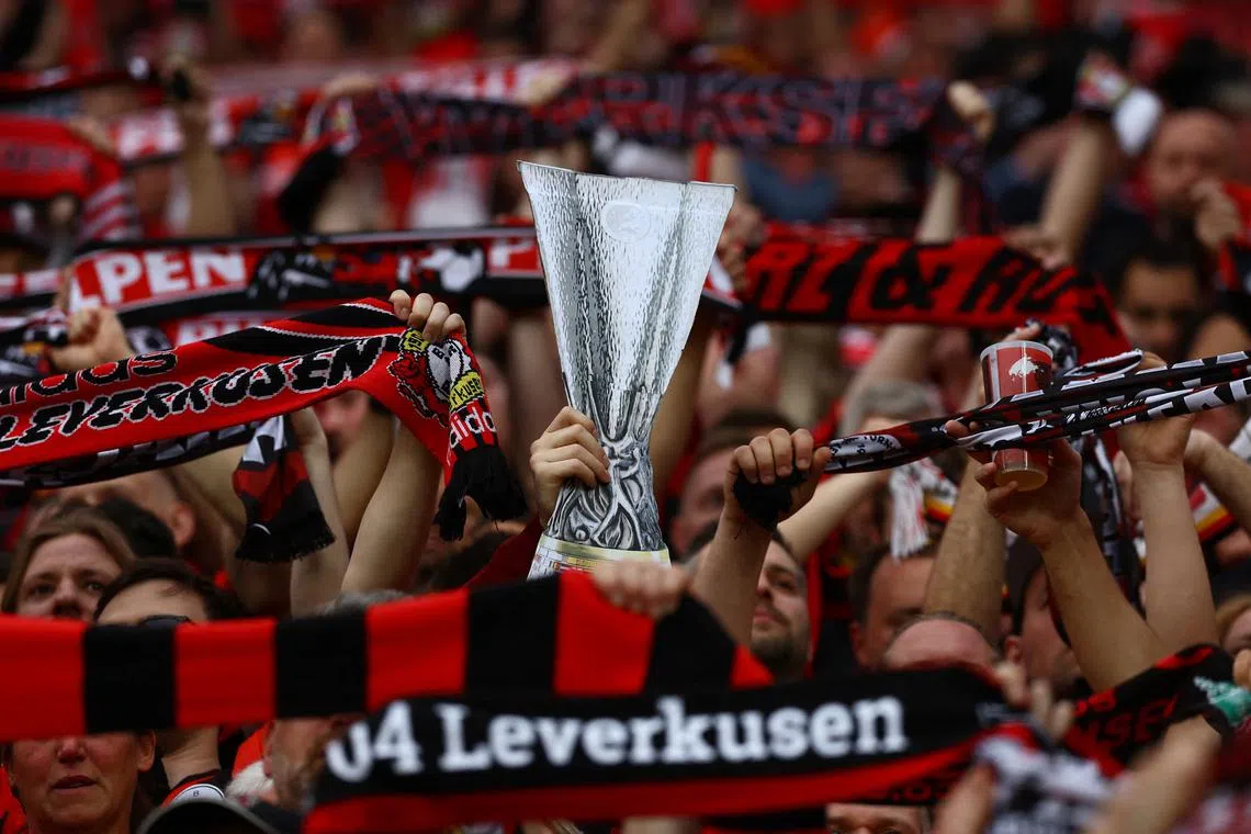 Soccer Football - Europa League - Semi Final - Second Leg - Bayer Leverkusen v AS Roma - BayArena, Leverkusen, Germany - May 9, 2024 Bayer Leverkusen fan with a cardboard cut out of the Europa League trophy inside the stadium before the match REUTERS/Kai Pfaffenbach