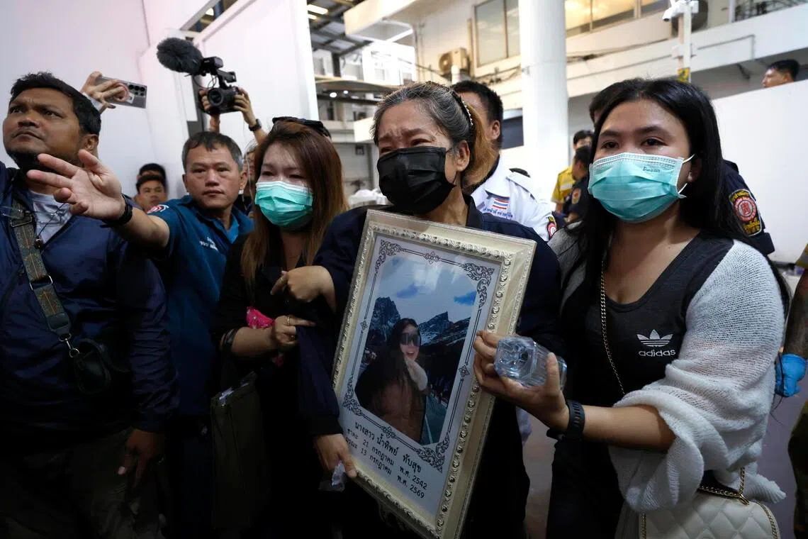 Family members break into tears as they collect the body of a woman who died with her husband in a pub fire at the Rong Beer Na Lat Phrao pub in Bangkok, Thailand.