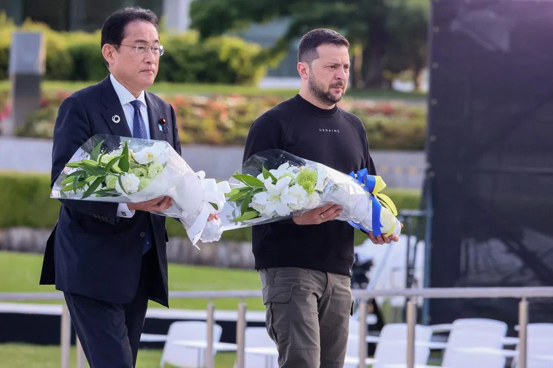 Japan's Prime Minister Fumio Kishida (L) and Ukraine's President Volodymyr Zelensky prepare to lay wreaths at the Cenotaph for the Victims of the Atomic Bomb at the Hiroshima Peace Memorial Park.