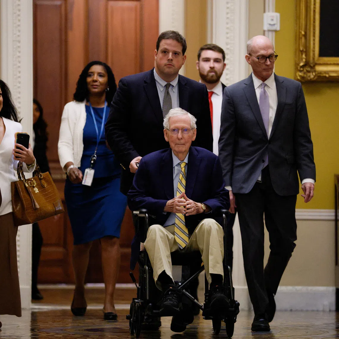 Senator Mitch McConnell (in wheelchair) arrives at the US Capitol on Sept 14.