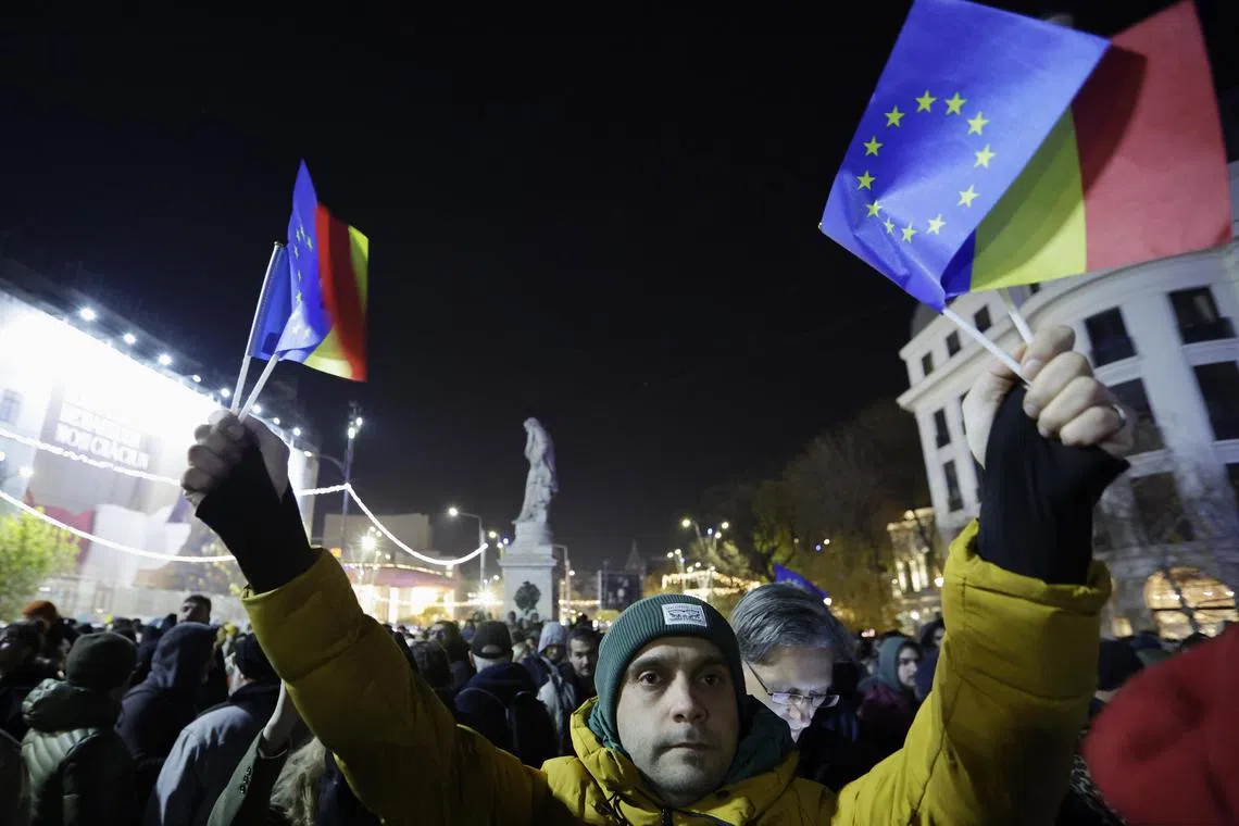 People shouting slogans and waving Romanian and EU flags during a pro-Europe rally ahead of the presidential runoff, in downtown Bucharest, on Dec 5.