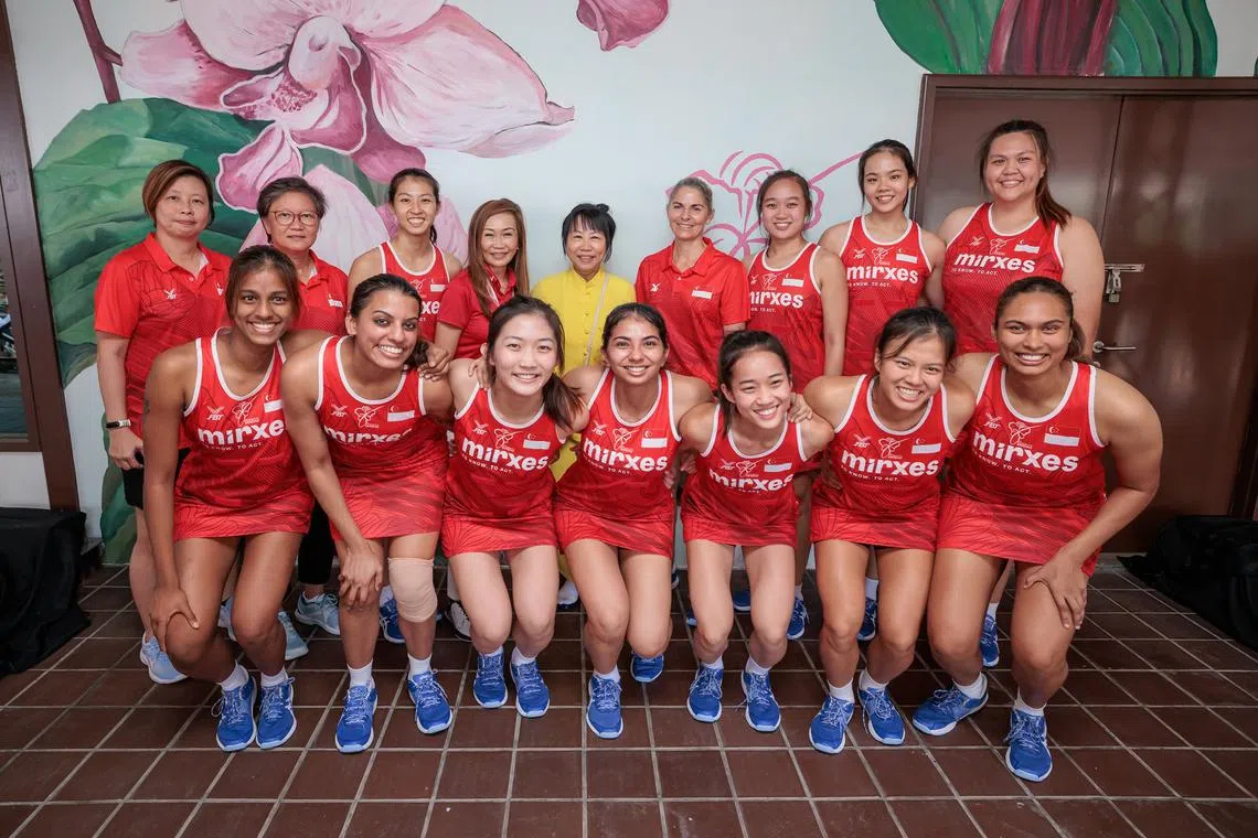 Ms Jane Ittogi (in yellow), spouse of President Tharman Shanmugaratnam, with the national netball team at Kallang Netball Centre on Aug 3.