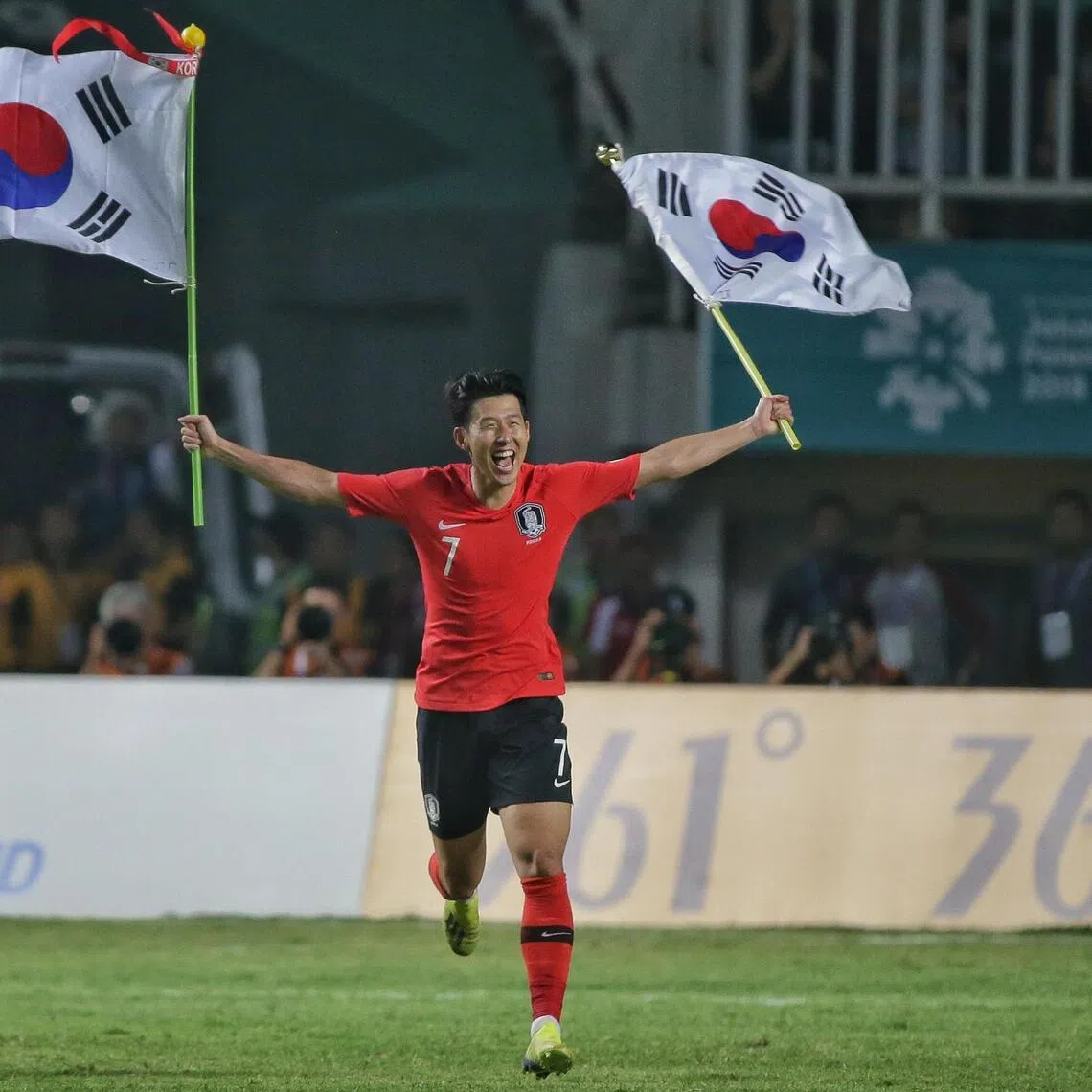 South Korea’s Son Heung-min gestures to supporters with two Korean flags after winning the final at the 18th Asian Games in Bogor, Indonesia, in 2018.