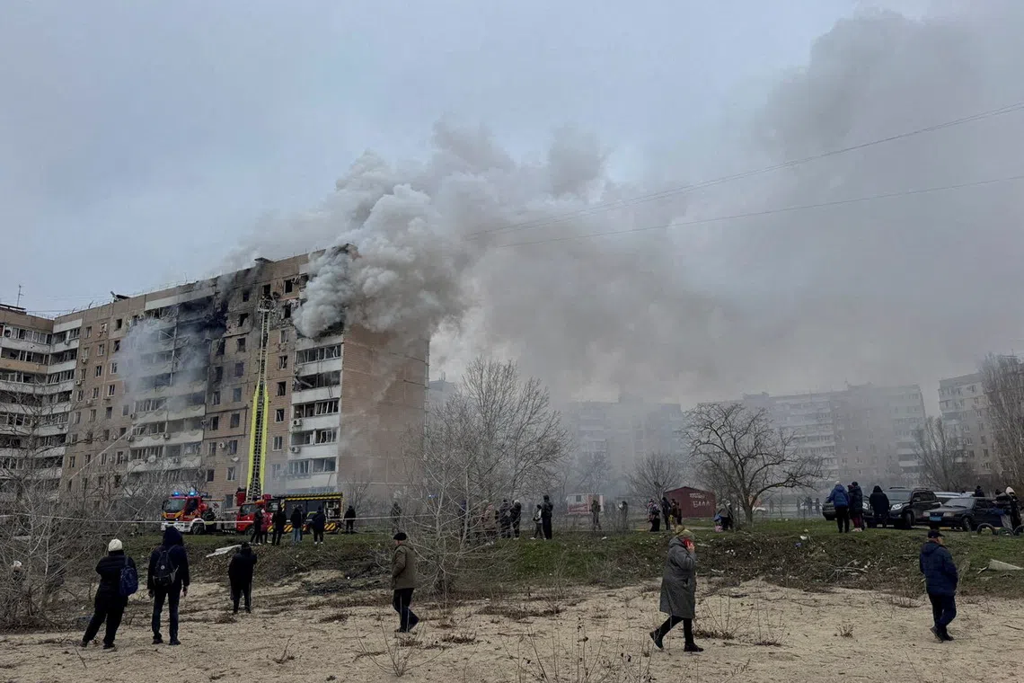 FILE PHOTO: Residents walk in front of an apartment building hit by a Russian air strike, amid Russia's attack on Ukraine, in Zaporizhzhia, Ukraine December 17, 2025. REUTERS/Stringer/File Photo