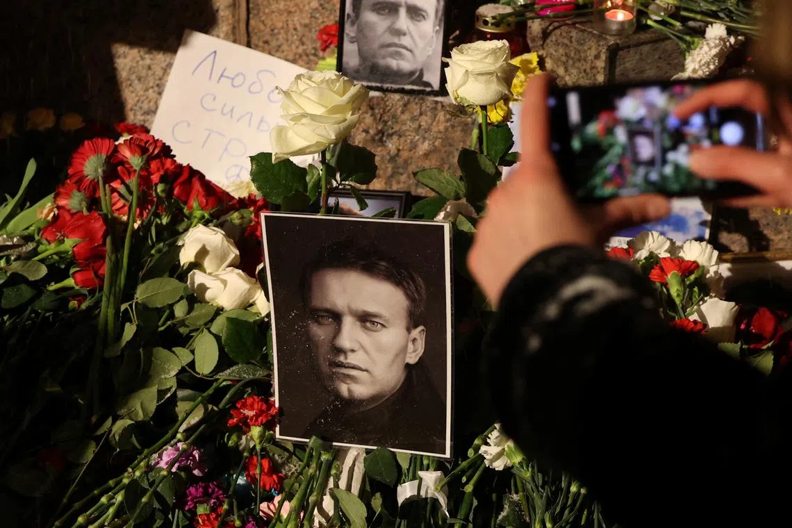 Flowers and portraits of Russian opposition leader Alexei Navalny are placed at the monument to the victims of political repressions following his death, in Saint Petersburg, Russia February 16, 2024. REUTERS/Stringer/FILE PHOTO