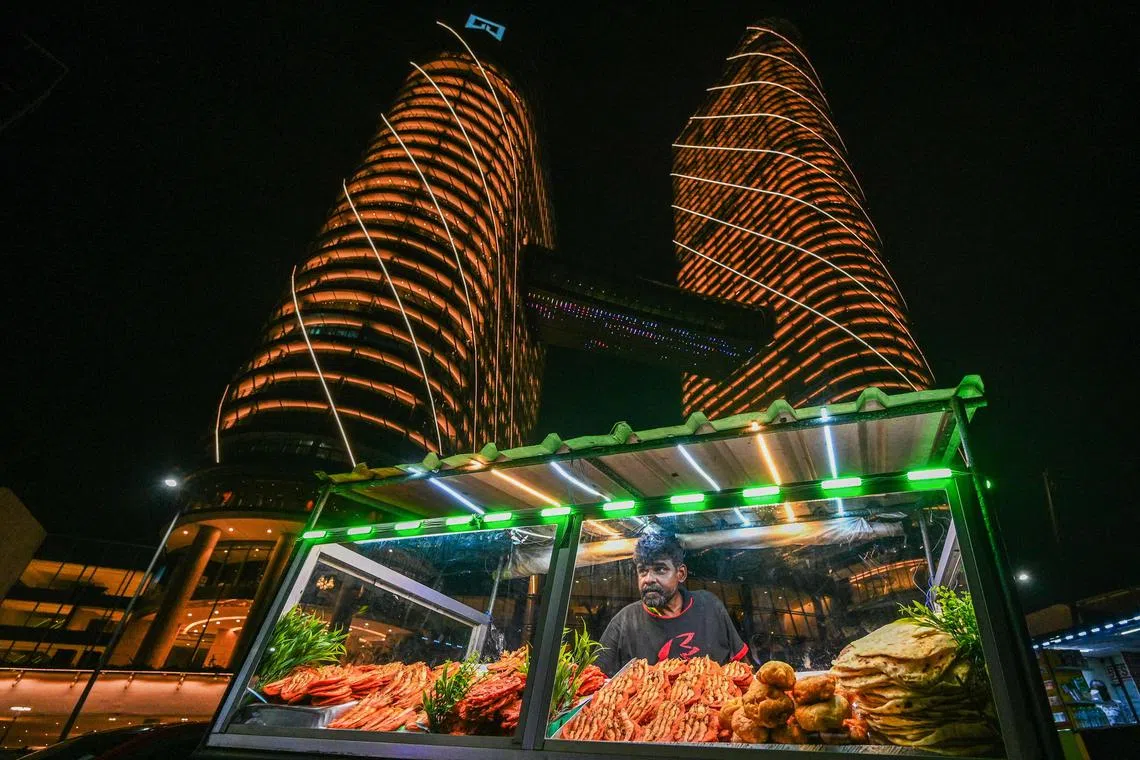 TOPSHOT - A street vendor sells prawns at the Galle Face sea-front promenade in Colombo on March 15, 2024. (Photo by Ishara S. KODIKARA / AFP)