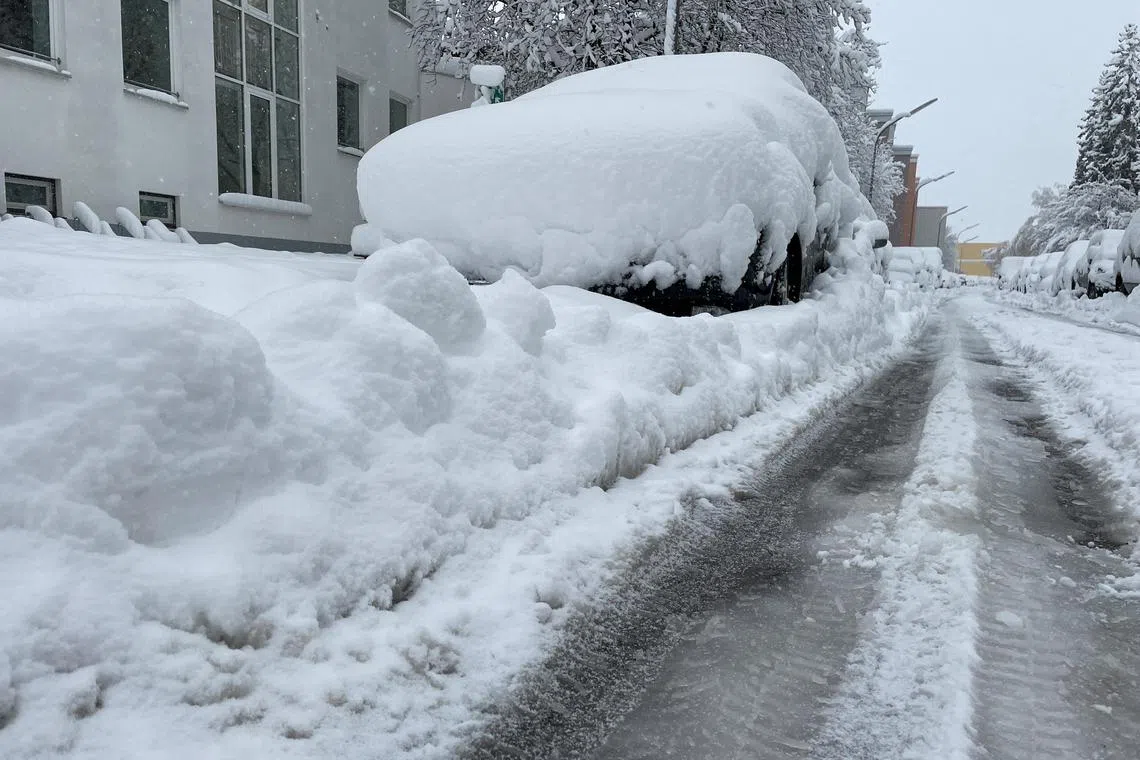 Snow-covered vehicles are parked in the streets after heavy snowfall hit Bavaria and its capital Munich in Germany in Dec 2023.  