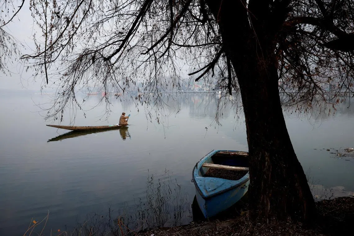 A man rowing his boat to collect garbage in the waters of Dal Lake on a cold morning in Srinagar, Indian Kashmir, on Jan 12, 2026. 