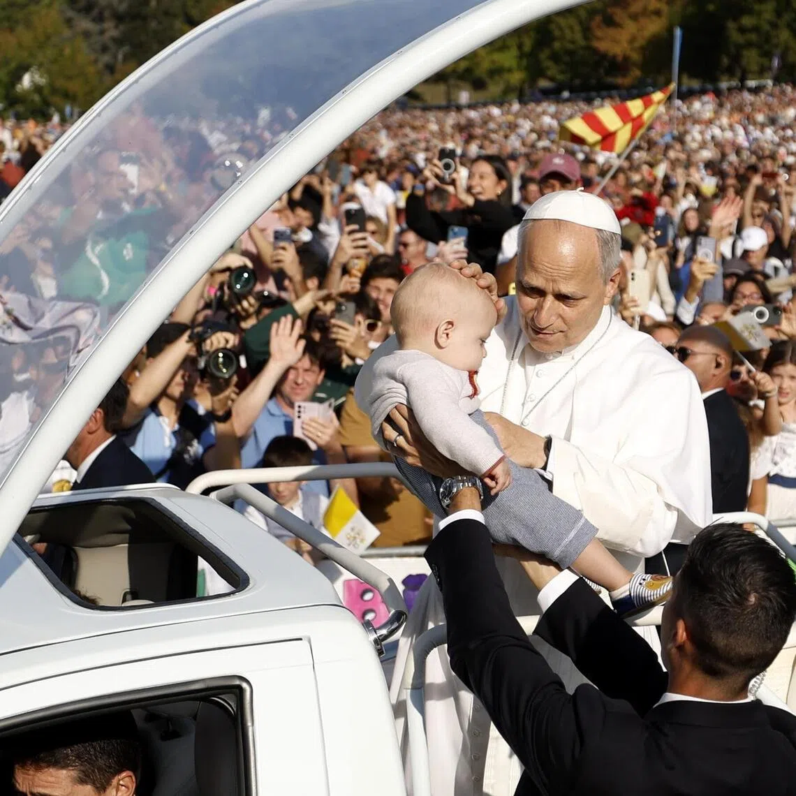 Pope Leo blessing a child as he arrives for mass at the Sanctuary of Our Lady of Lourdes in France on Sept 27.
