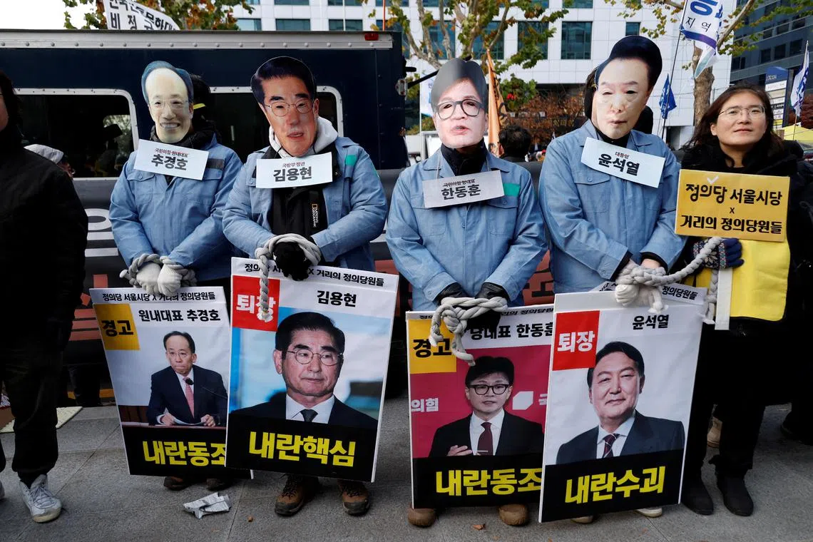 Protesters wearing masks depicting South Korean President Yoon Suk Yeol, outgoing Defence Minister Kim Yong-hyun, People Power Party's leader Han Dong-hoon and Choo Kyung-ho at a rally calling for the impeachment of Mr Yoon. 