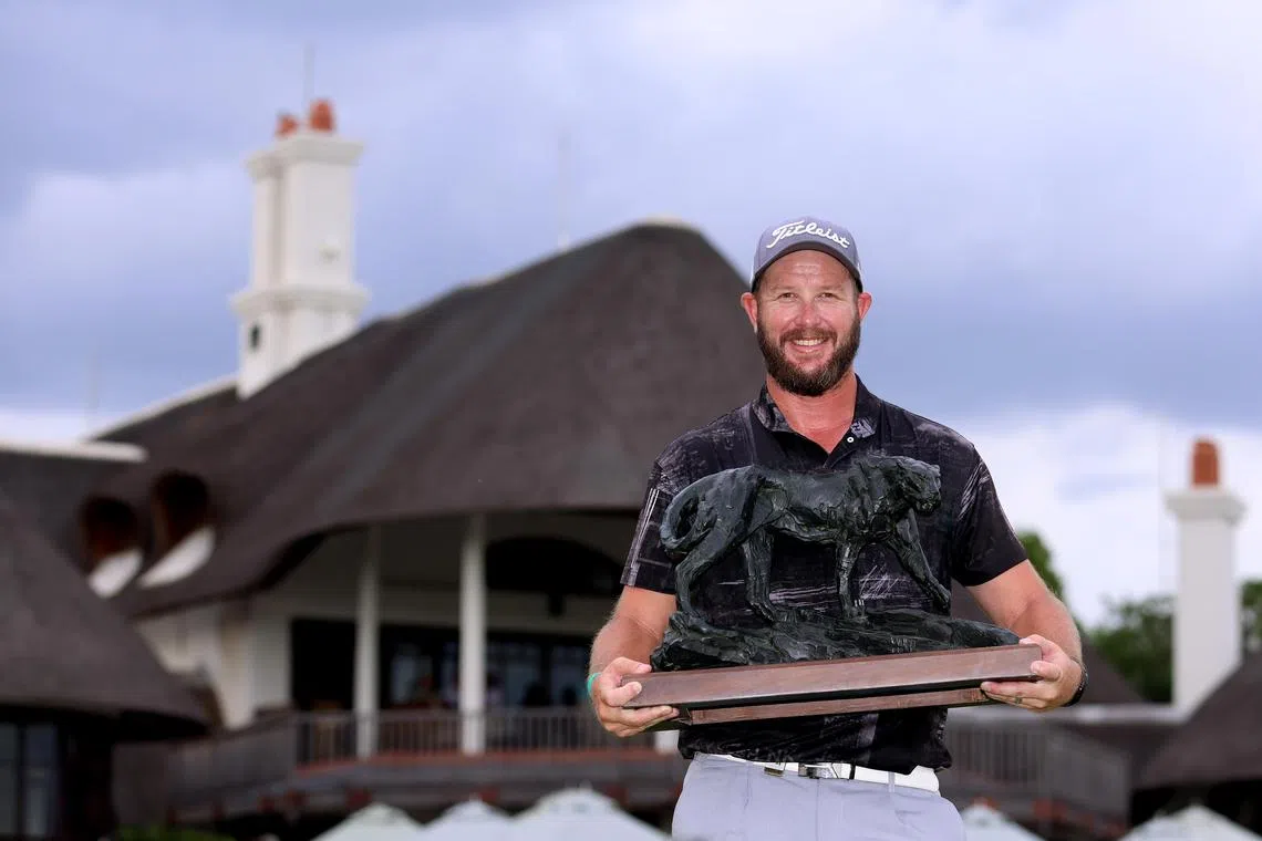 South African Ockie Strydom lifts the Alfred Dunhill Championship trophy after winning the Championship on Sunday.