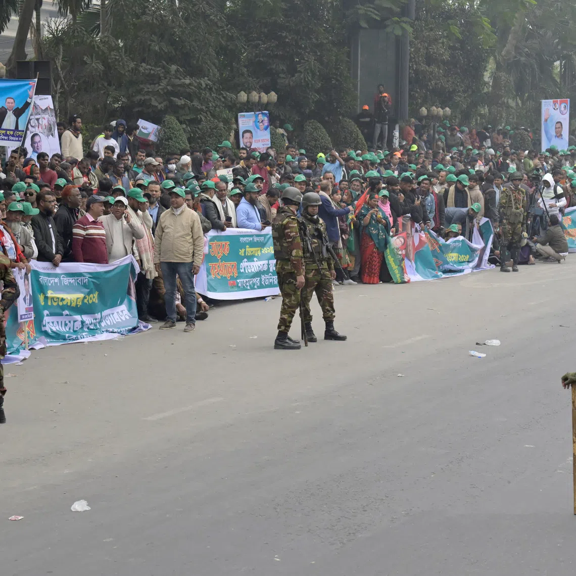 Bangladesh Army soldiers stand guard next to supporters of the Bangladesh Nationalist Party (BNP) as they gather to welcome BNP acting chairman Tarique Rahman after his return from London, in Dhaka, Bangladesh, December 25, 2025. REUTERS/Fatima Tuj Johora