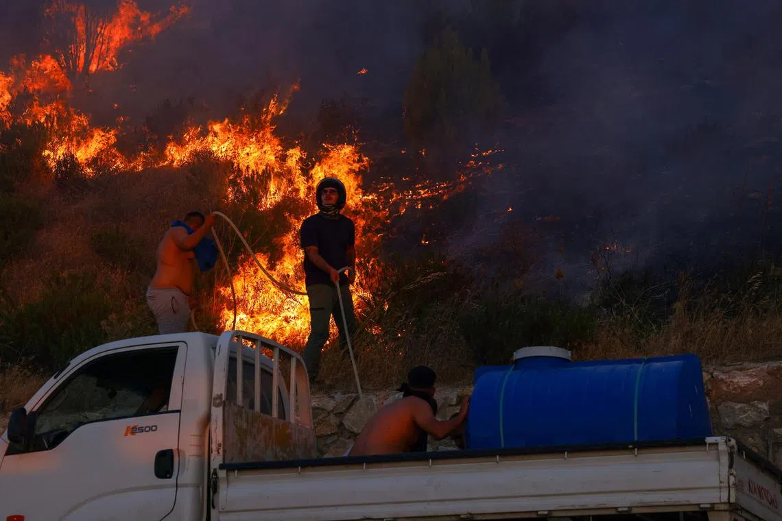 People try to extinguish a wildfire in the northwestern city of Canakkale province, Turkey, August 11, 2025. REUTERS/Dilara Senkaya       TPX IMAGES OF THE DAY