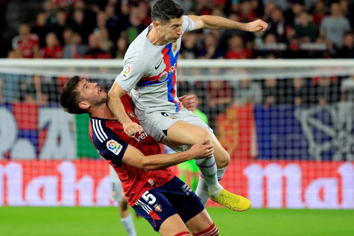 Barcelona's Robert Lewandowski fouls Osasuna's David Garcia before being shown a red card.
