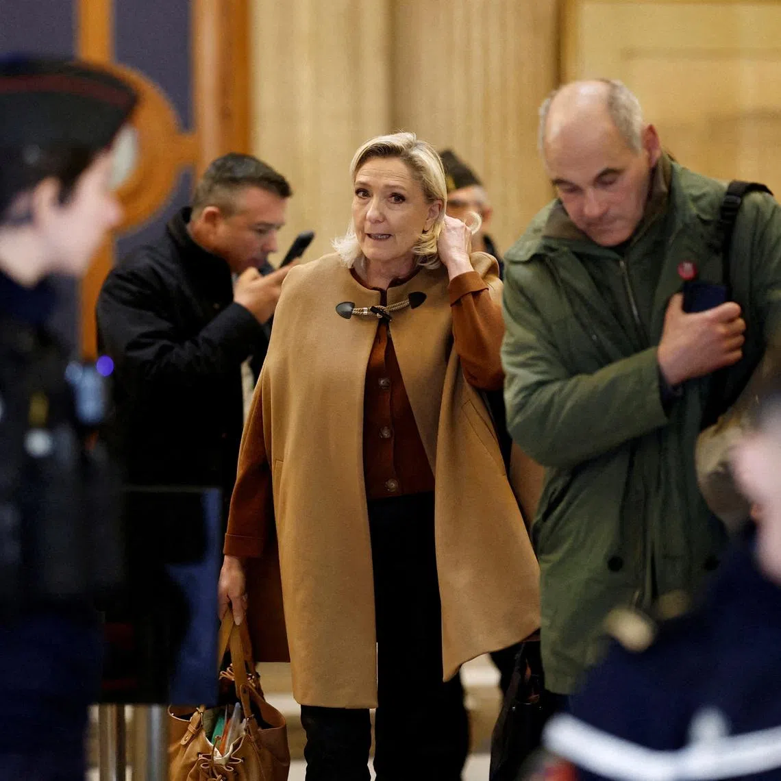 French far-right leader Marine Le Pen, member of parliament for the Rassemblement National (National Rally - RN) party, leaves a hearing during which civil parties will be heard and prosecutors will present their sentencing request in her appeal trial, alongside the RN party itself and 10 others defendants found guilty of diverting European Parliament funds, at the Paris courthouse on the Ile de la Cite, in Paris, France. REUTERS/Benoit Tessier