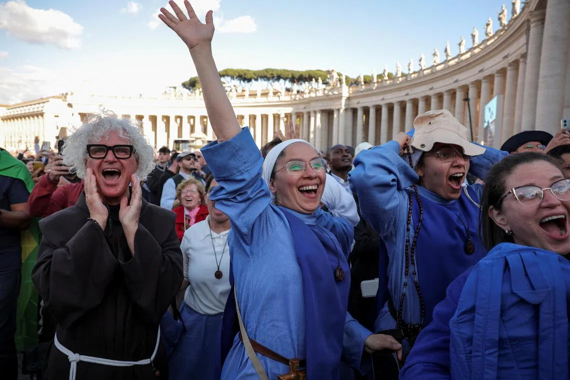 Nuns rejoicing as white smoke rises from the chimney of the Sistine Chapel, signaling the election of a new pope at the Vatican on May 8.
