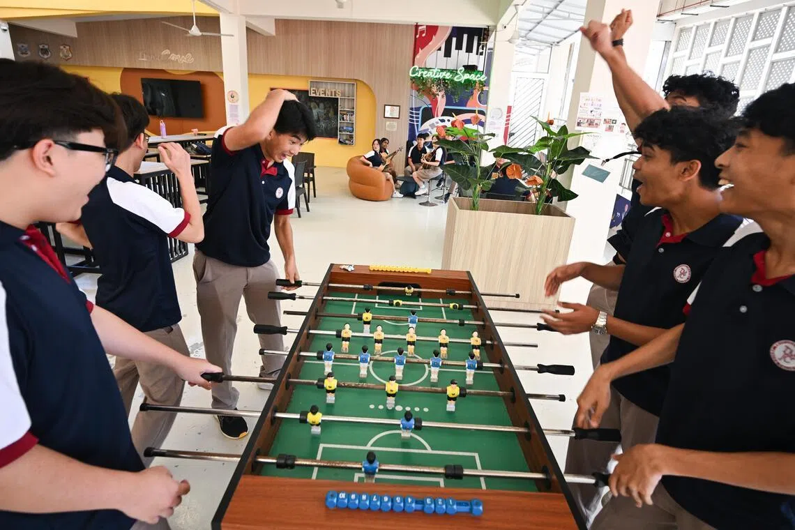 Students playing foosball on March 10 at Tampines Meridian Junior College, where the canteen comprises four distinct zones for different uses, including a performance space.