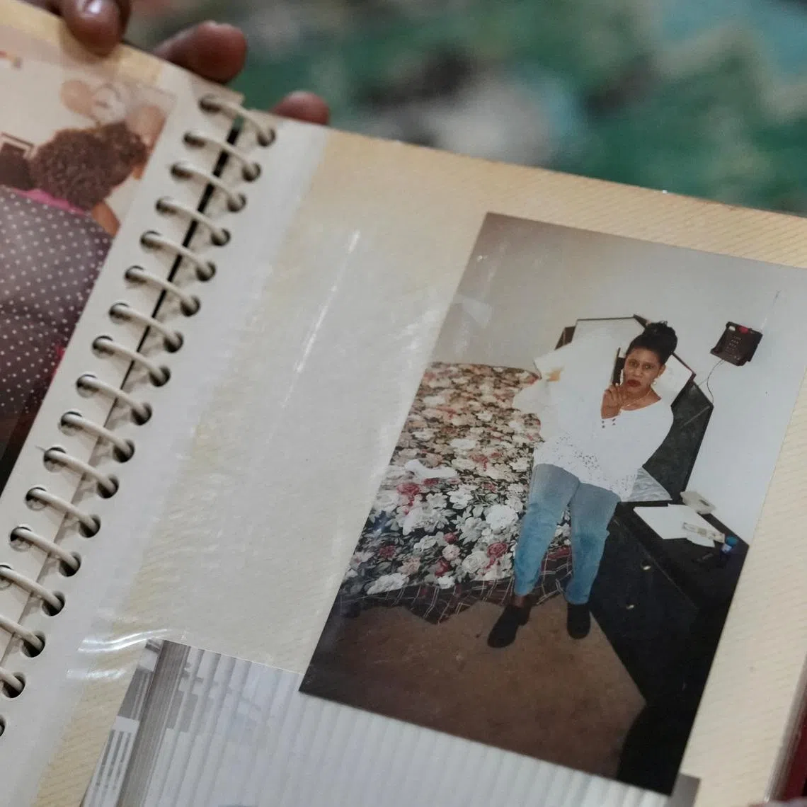 Mohamed Alghali, 33, looks at an album containing photographs of his mother, Rabbiatu Kuyateh, at the home they shared in Bowie, Maryland, U.S., December 10, 2025. Kuyateh was deported in November to Ghana, which has an agreement with the Trump administration to take West African migrants who cannot easily be sent to their home countries. She said she was then flown against her will to her native Sierra Leone, where she feared she could be tortured because of her father's ties to the political opposition. REUTERS/Julio-Cesar Chavez