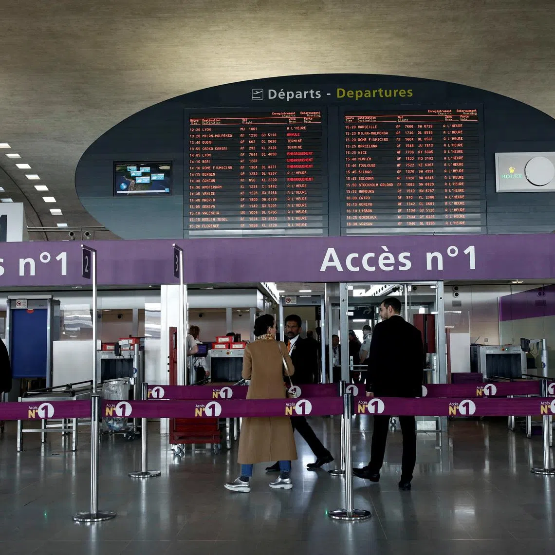 FILE PHOTO: Passengers gather in a departure hall as screens display flight information inside Charles de Gaulle airport, operated by Aeroports de Paris, in Roissy, France, April 11, 2019. REUTERS/Benoit Tessier/File Photo