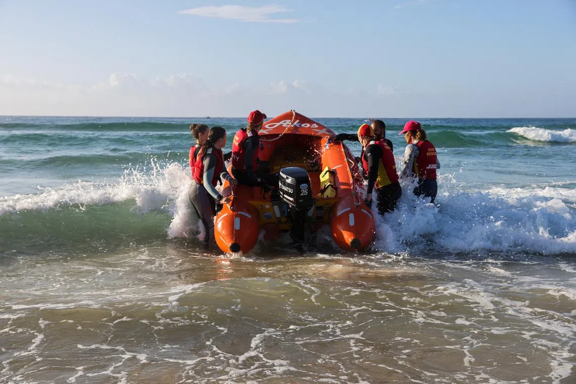 Bondi Beach Inflatable Rescue Boat (IRB) Racing team carries a boat into the ocean on Bondi Beach in Sydney, Australia February 17, 2024. REUTERS/Alasdair Pal