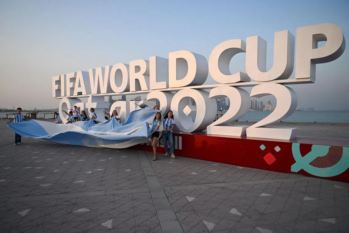Argentina's fans cheer in front of a World Cup sign in Doha on Monday ahead of the start of the tournament on Nov 20. Homosexuality is illegal in the conservative Muslim country, and some football players have raised concerns over the rights of fans travelling for the event, especially LGBT+ individuals and women, whom rights groups say Qatari laws discriminate against.