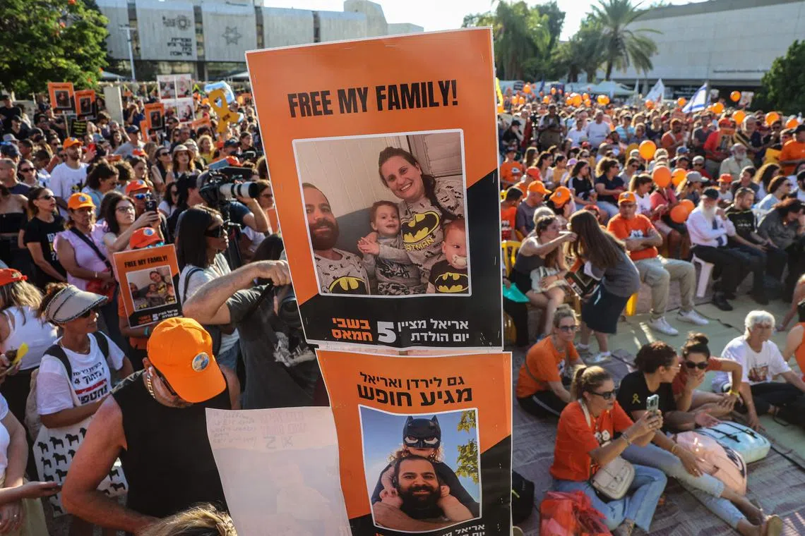 Participants lift placards and pictures during a gathering in Tel Aviv to mark the fifth birthday of Ariel Bibas, held hostage in Gaza.