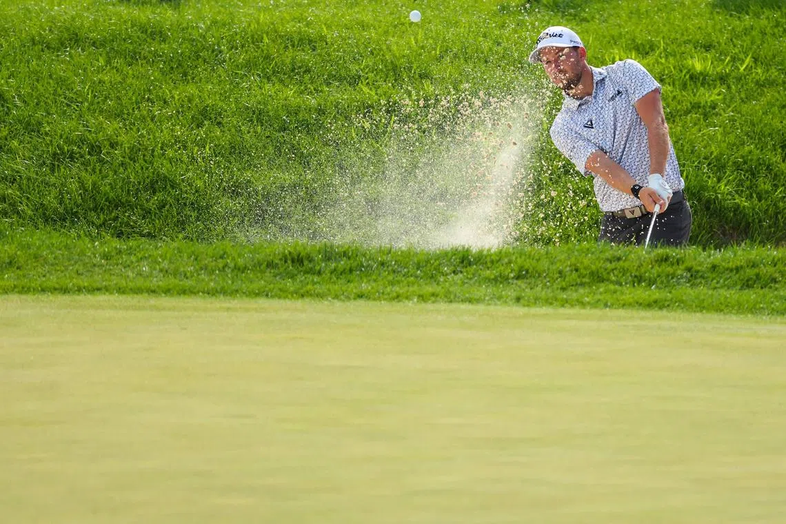 Lee Hodges of the United States playing a shot from a bunker on the 18th hole during the third round of the 3M Open at TPC Twin Cities on Saturday in Blaine, Minnesota. He sits atop the leaderboard on 20-under 193 after recording a five-under 66 on Saturday.