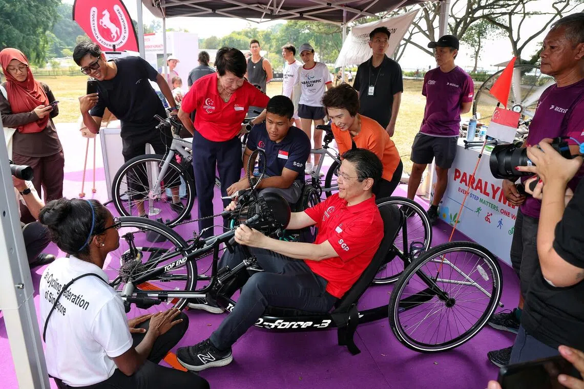 Prime Minister Lawrence Wong (seated) trying out a recumbent hand cycle at the launch of the inaugural Paralympic Day at Angsana Green, East Coast Park, on Aug 29, 2026.