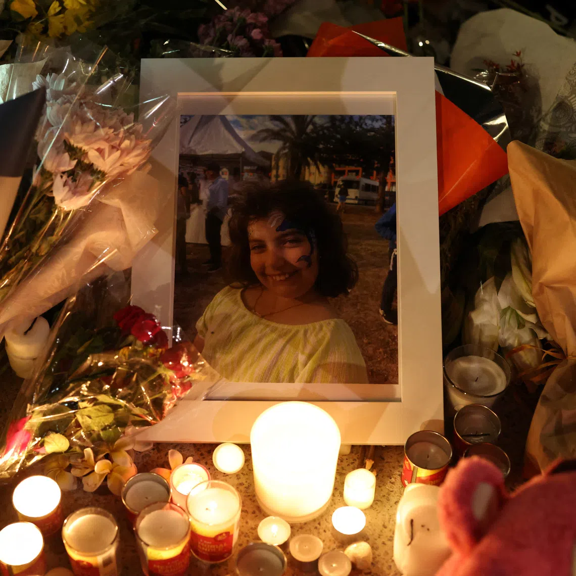 A photograph of Matilda Britvan, 10, a victim of a shooting at Jewish holiday celebration on Sunday at Bondi Beach, lies amongst floral tributes in Sydney, Australia, December 16, 2025. REUTERS/Hollie Adams