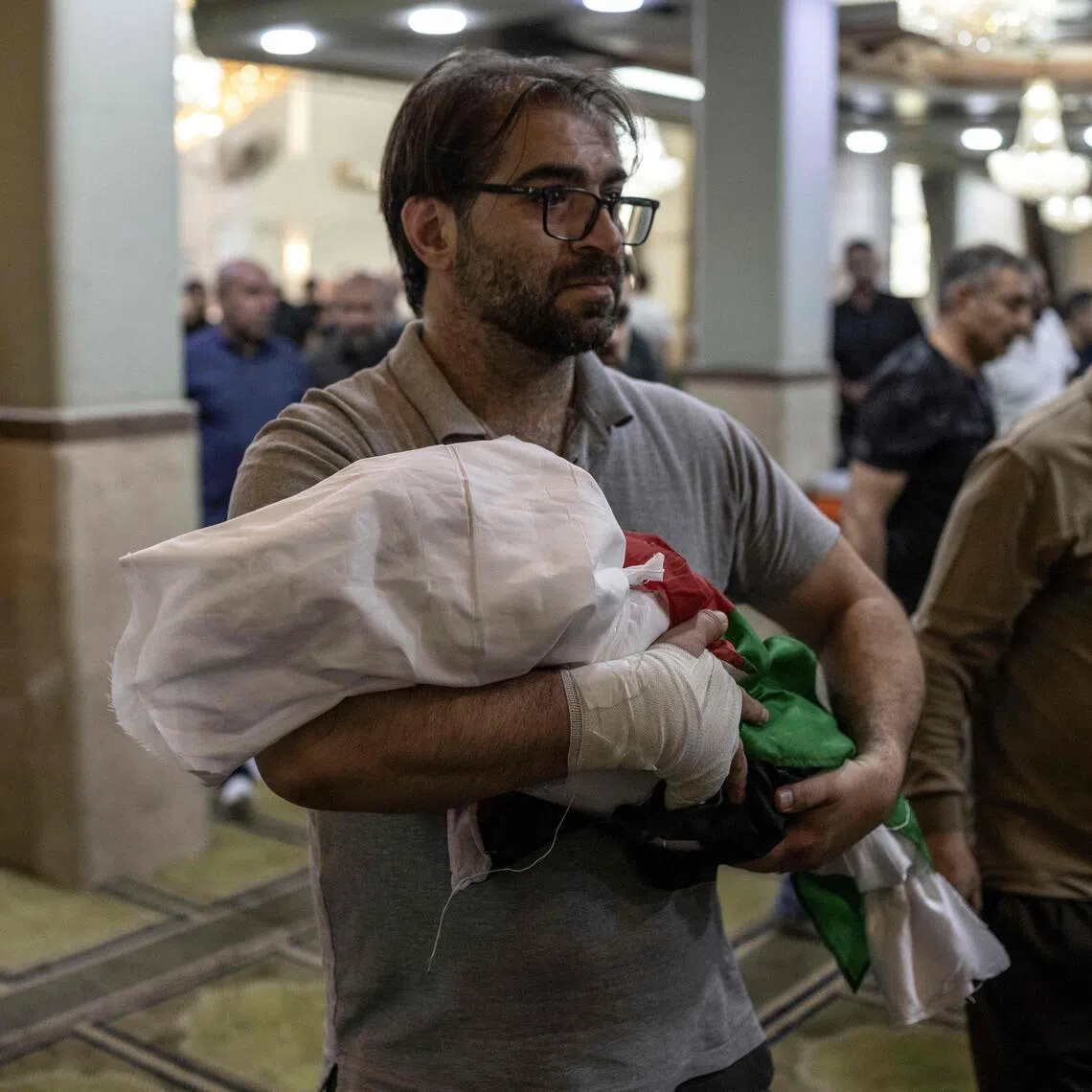 Palestinian Fahd Abou Haikal carrying the body of his seven-month-old son at the Abou Heisheh Mosque in Hebron, in the occupied West Bank, on June 6.
