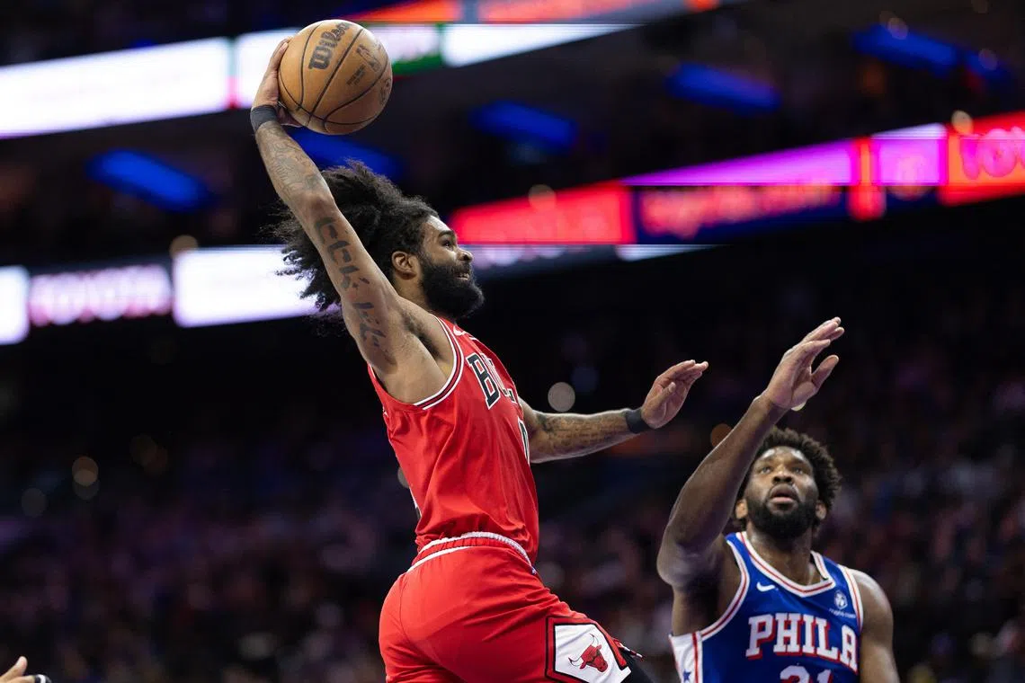 Chicago Bulls guard Coby White drives for a dunk past Philadelphia 76ers centre Joel Embiid during the third quarter at Wells Fargo Centre.