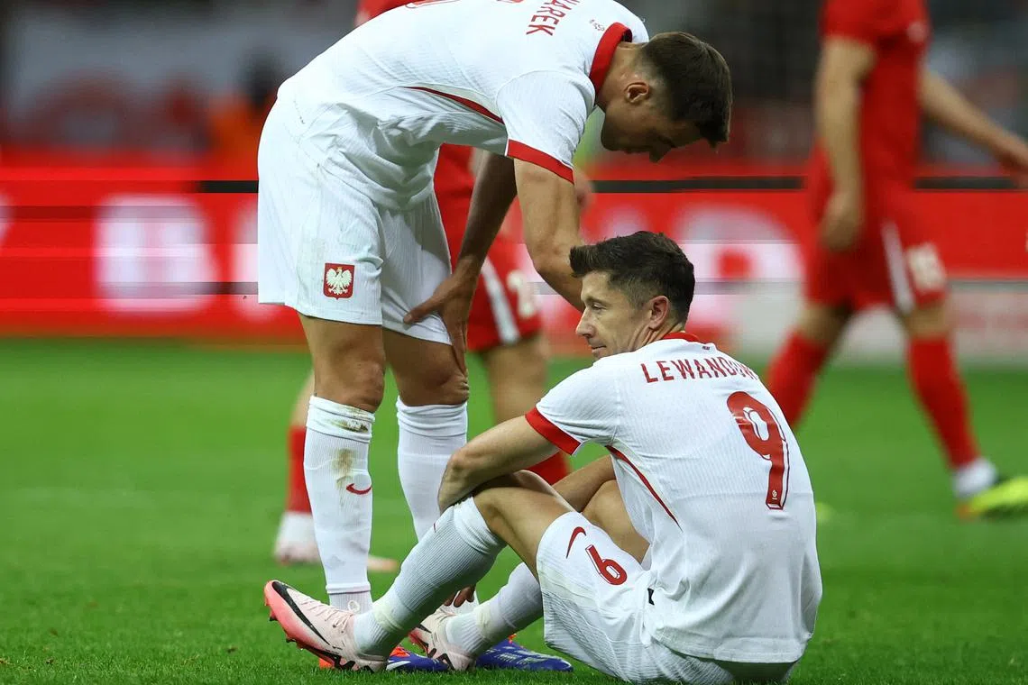 FILE PHOTO: Soccer Football - International Friendly - Poland v Turkey - National Stadium, Warsaw, Poland - June 10, 2024 Poland's Robert Lewandowski is consoled by Jan Bednarek after sustaining an injury REUTERS/Kacper Pempel/File Photo