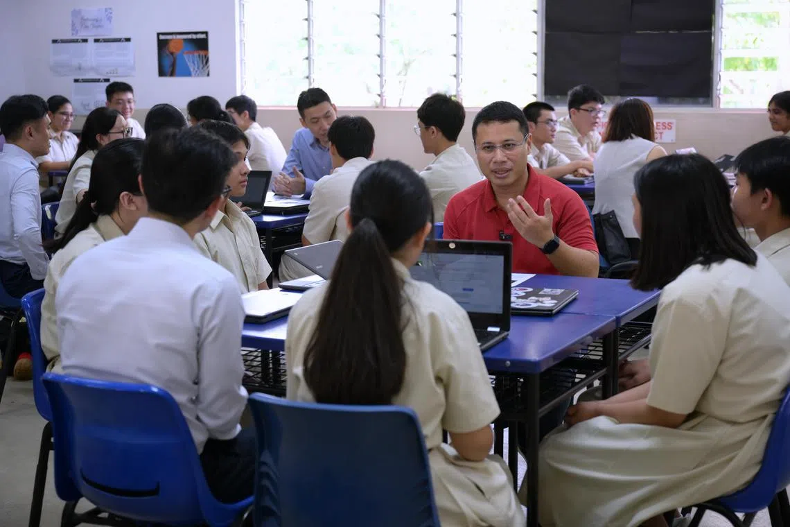 Minister for Education Desmond Lee (in red shirt) and Senior Minister of State for Education David Neo (in blue shirt at table behind) at Mayflower Secondary School on July 18.