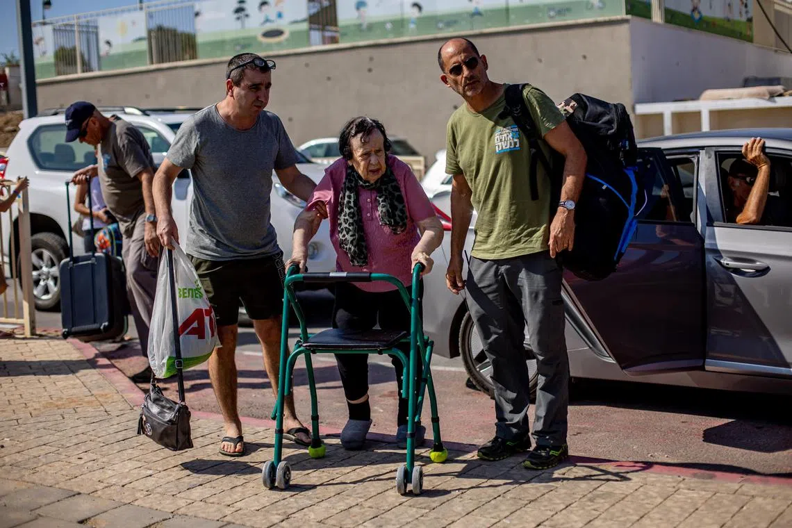 People prepare to board a bus, as residents are evacuated from the city of Sderot, Israel.