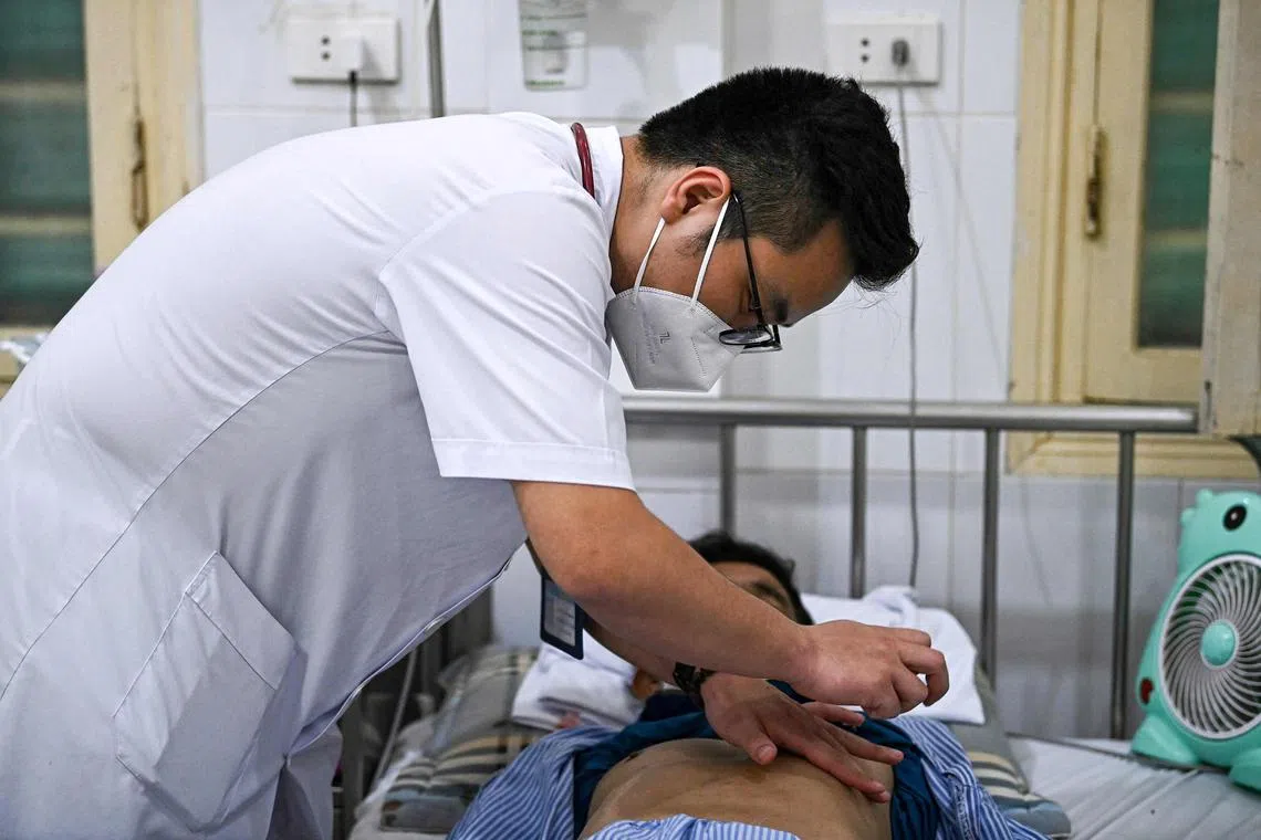 A doctor with a drug-resistant tuberculosis patient at a hospital in Hanoi.