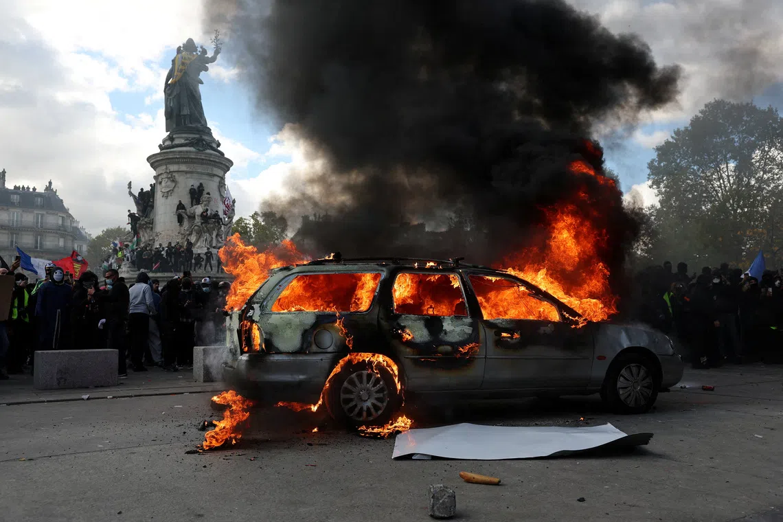 A car burns amid clashes between protesters and the French police during a demonstration in France, on Oct 17.