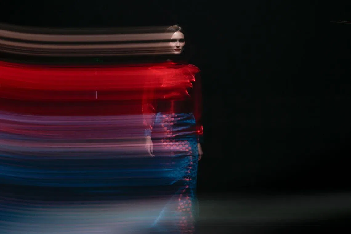 TOPSHOT - A slow shutter speed exposure shows a model displaying a creation from the AM/JASMINE collection by Liang Chen and Claire Jialing Chen during the China Fashion week in Beijing on September 7, 2026. (Photo by WANG Zhao / AFP)
