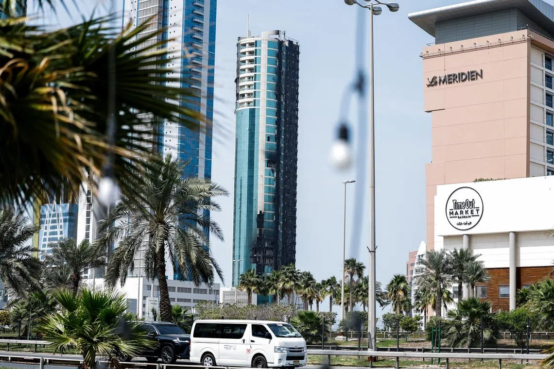 Vehicles drive past a building that was damaged by an Iranian drone attack, after Israel and the U.S. launched strikes on Iran, in Seef, Manama, Bahrain, March 1, 2026. REUTERS/Hamad I Mohammed