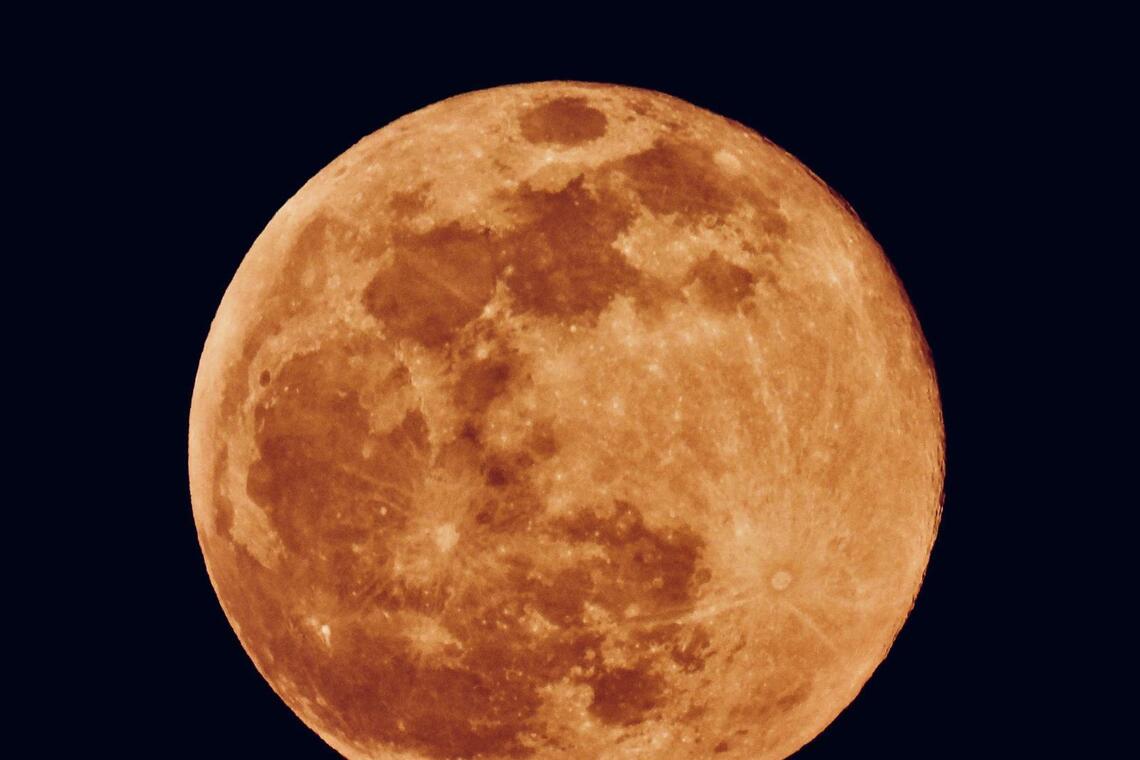 The super full moon glows orange on Oct 7, photographed from the top floor of Mandai Tekong Park.