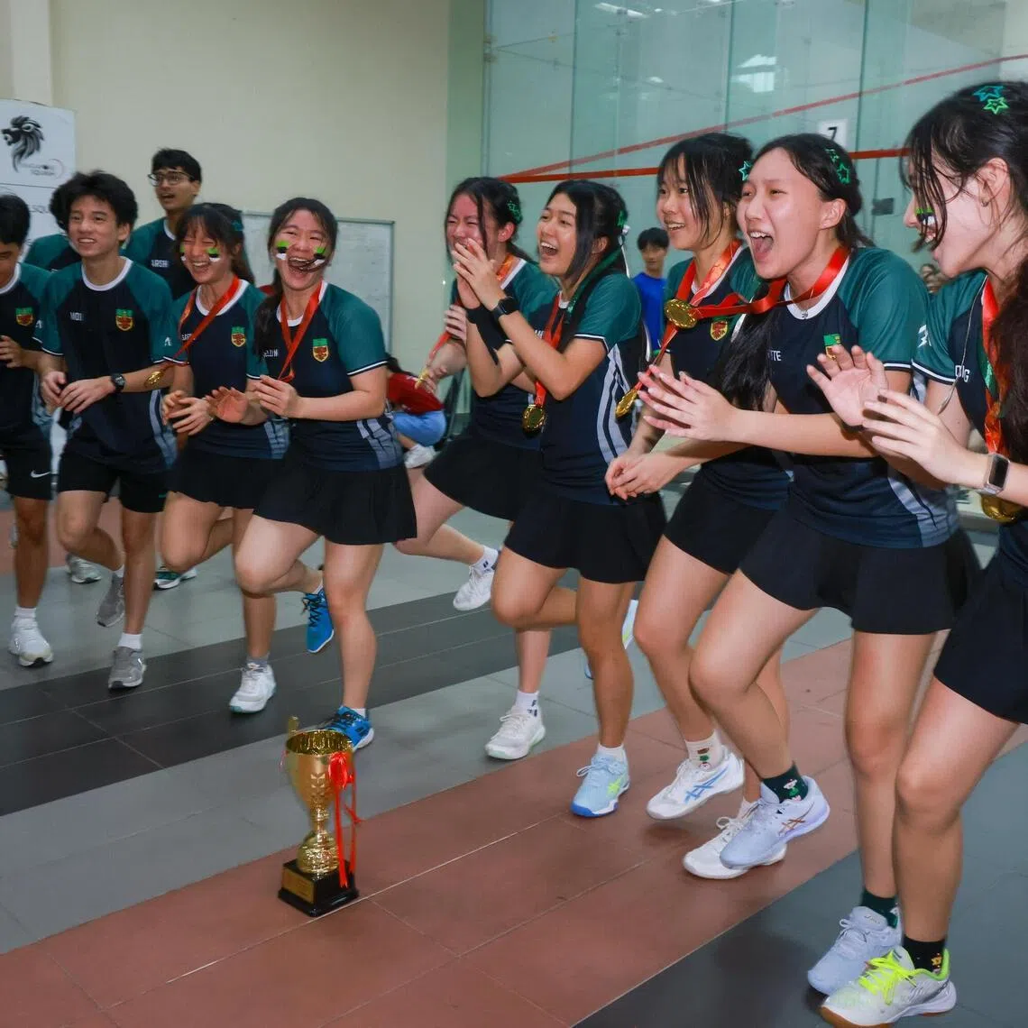  Raffles Institution cheering with teammates and supporters after RI won the Girls A Division Squash final at Kallang Squash Centre on May 6, 2026. 