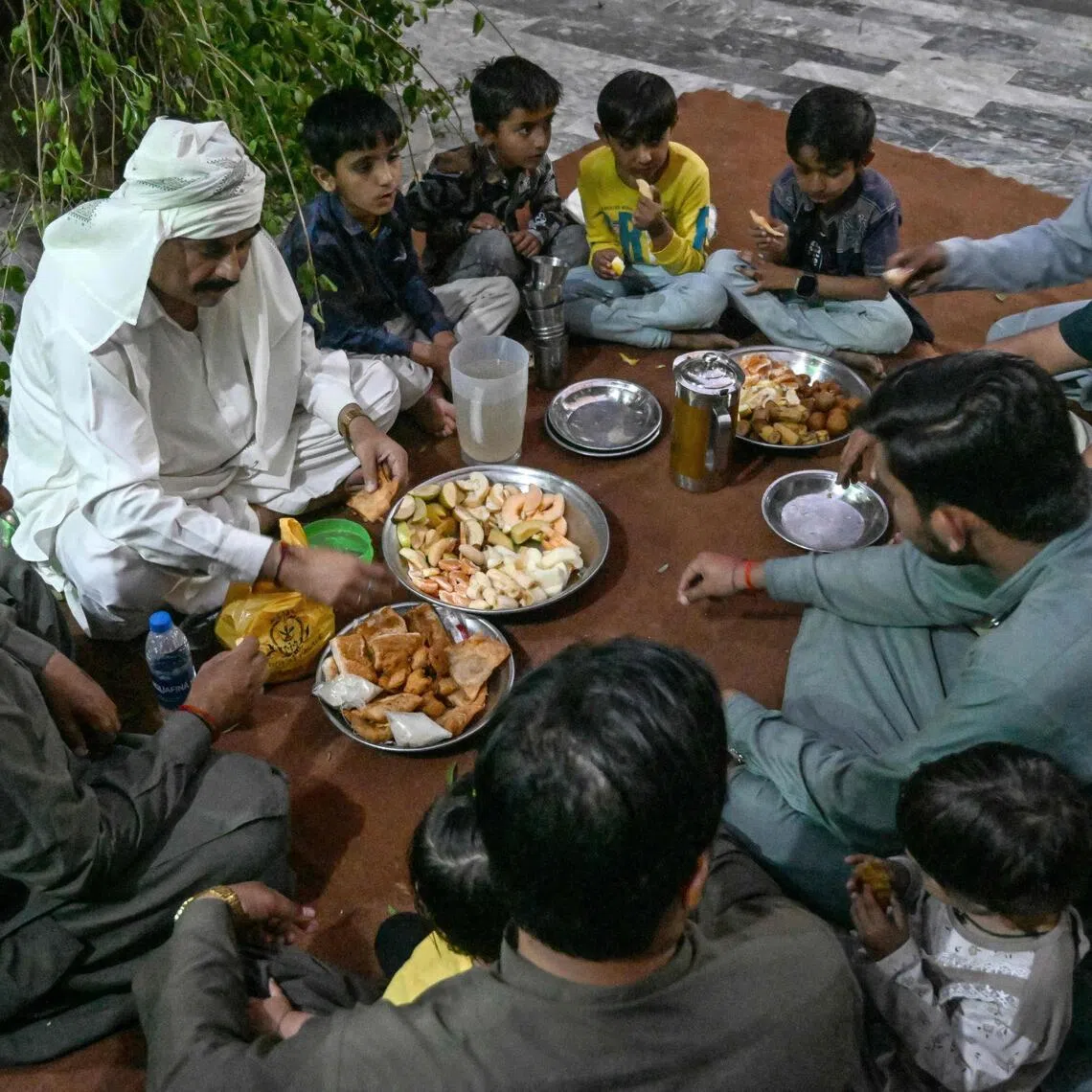 Mr Mohan Lal Malhi (2L), a Hindu caretaker of a Sufi shrine, breaking his fast during the Islamic holy fasting month of Ramadan at Mithi in the Tharparkar district of Sindh province.