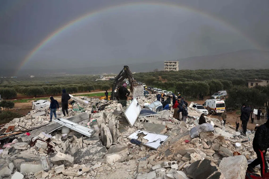 Residents search for victims and survivors amidst the rubble of collapsed buildings following an earthquake in the village of Besnaya, in Syria's rebel-held northwestern Idlib province on the border with Turkey, on Feb 6, 2022. 